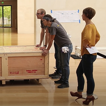 Registrar Melisa Durkee oversees an artwork installation