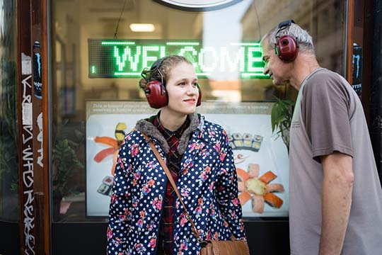 woman with headphones on an electrical walk by caitlin woolsey